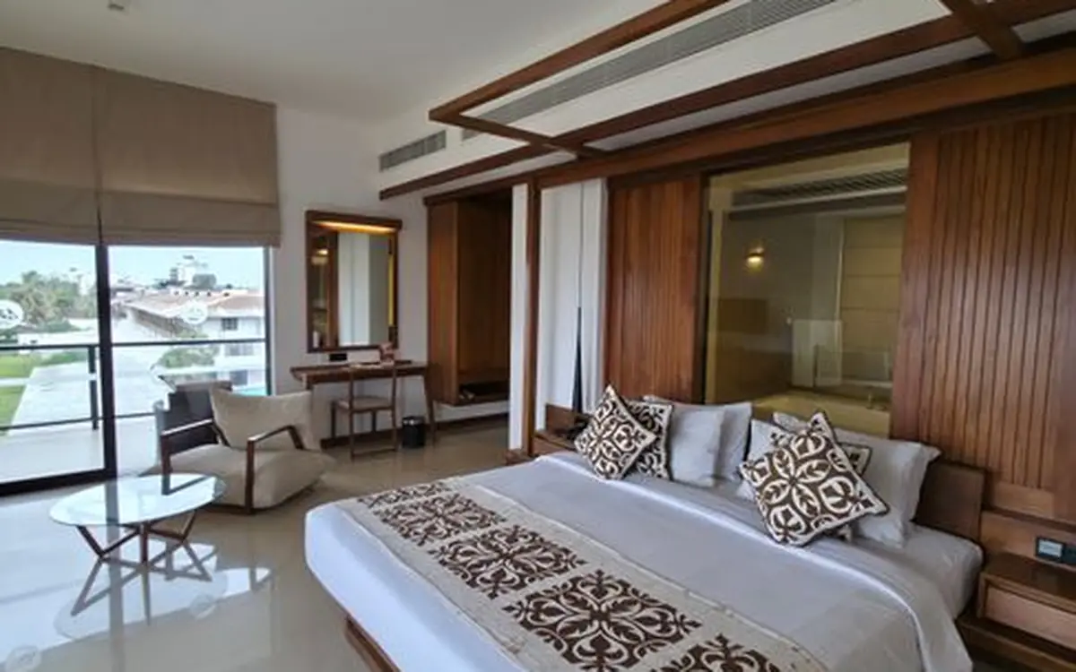 A bright hotel room with a balcony